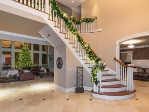 Inside of home with decorated stairs that lead up to second floor