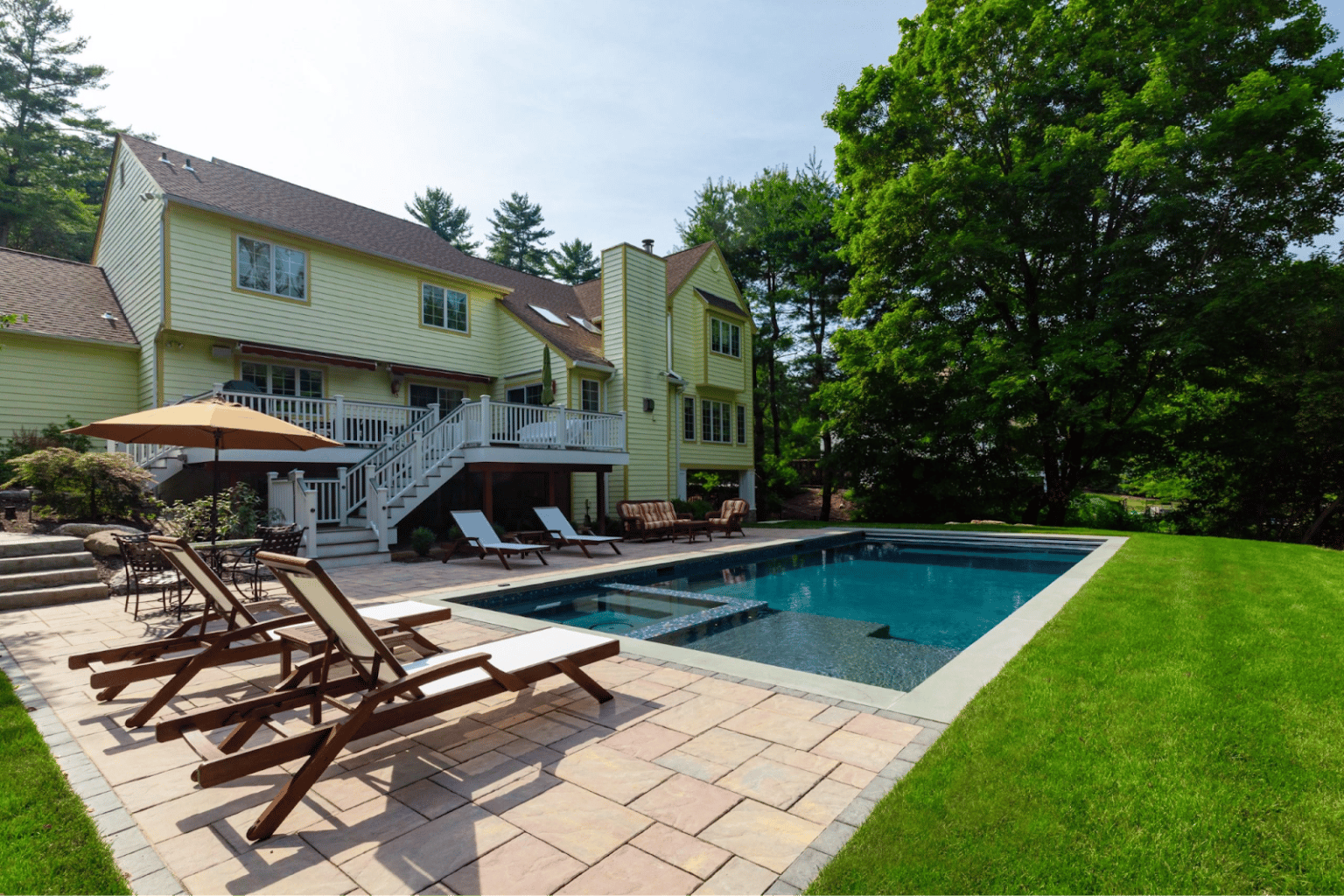 Tranquil pool with surrounding greenery and relaxing loungers, displaying Neave Group’s expertise in designing pools that avoid common mistakes and enhance overall landscape aesthetics