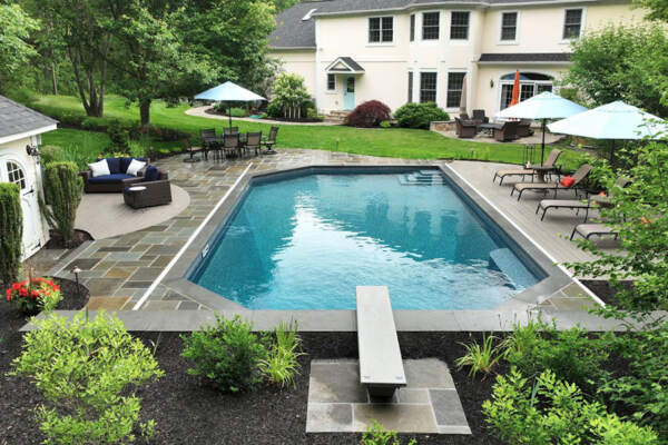 A private outdoor oasis featuring a minimalist pool with a diving board