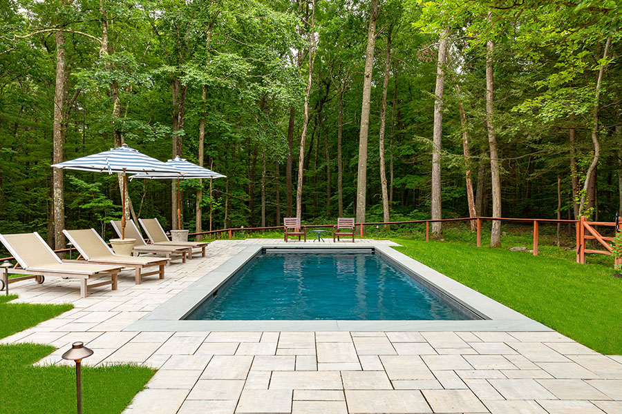 Inviting outdoor pool surrounded by pool umbrellas and chairs, nestled in lush greenery, exemplifying the excellence of NY pool cleaning services. Inviting outdoor pool surrounded by pool umbrellas and chairs, nestled in lush greenery, exemplifying the excellence of NY pool cleaning services.