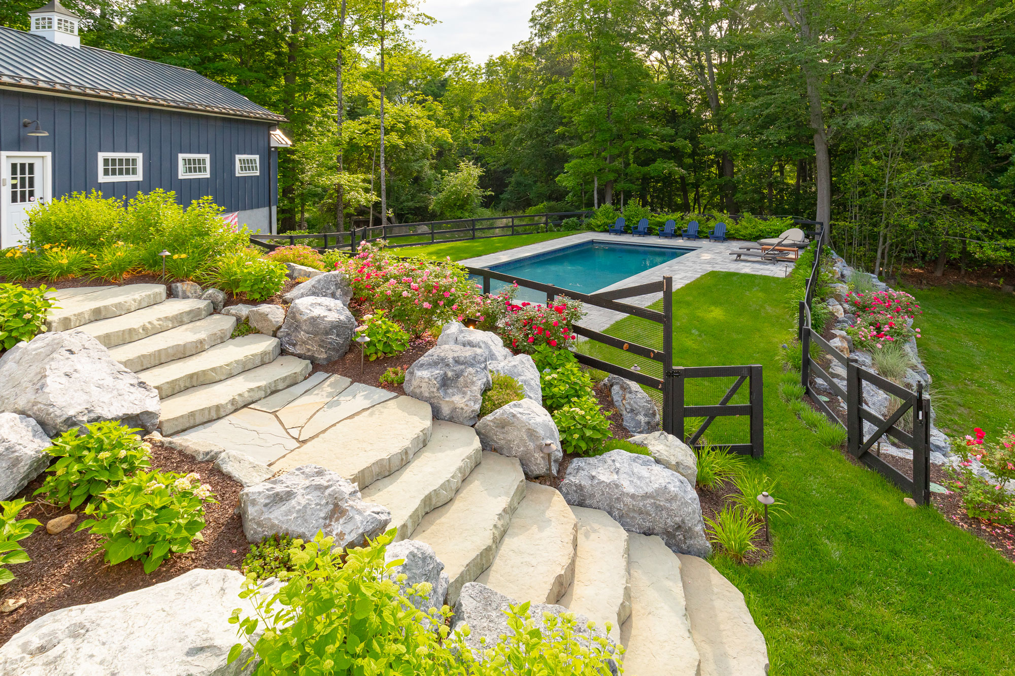 Manicured landscaping and walkway hardscaping overlooking a custom pool near New York City by Neave Outdoor
